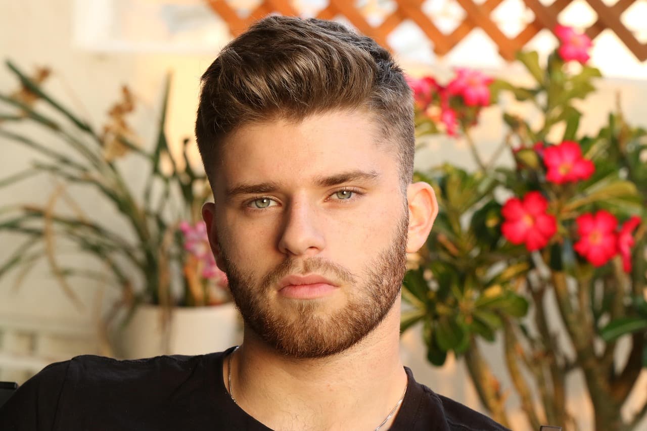 A young man with a textured quiff, short sides and a trimmed beard