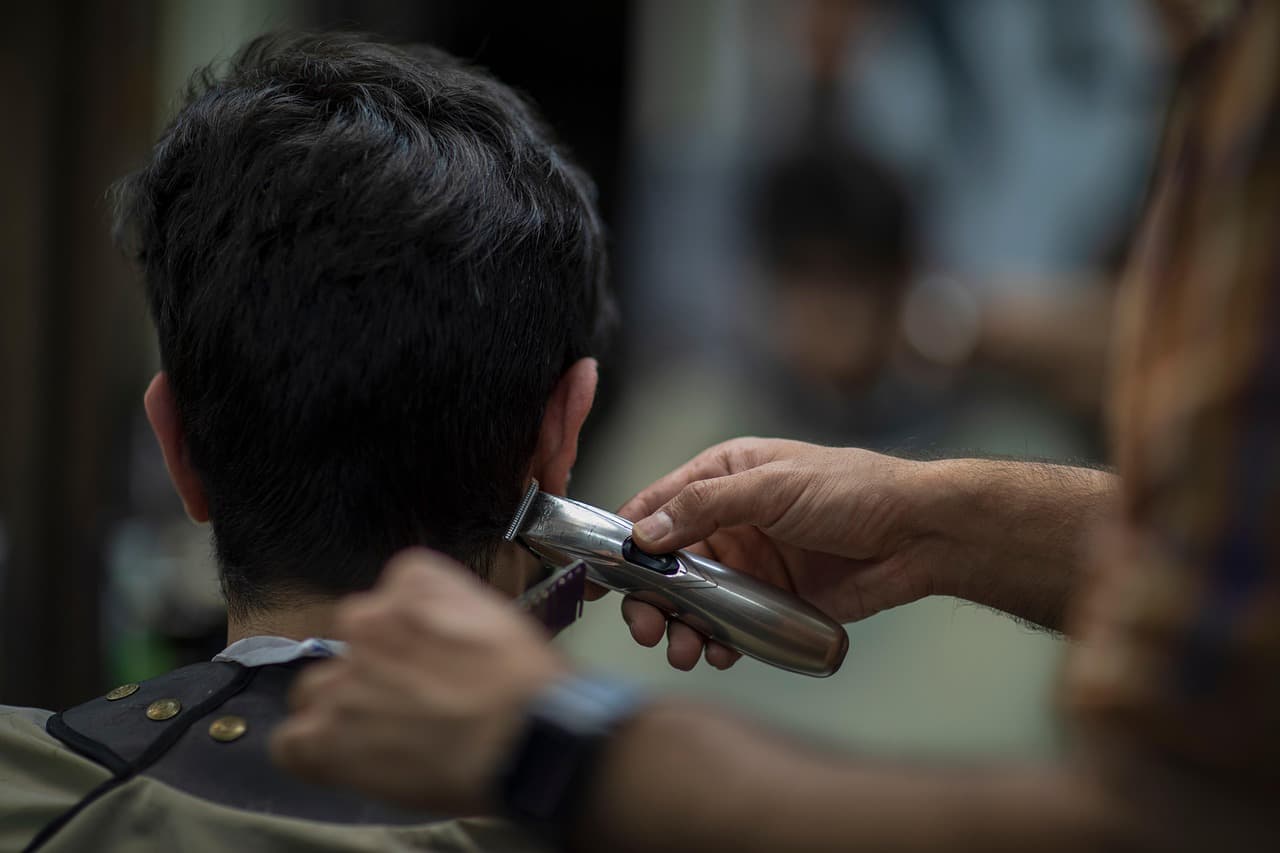 Clippers tidying the neckline at the back of a customer's head